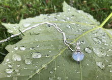 Load image into Gallery viewer, Silver petaled translucent opal-like white flower, with tiny pearl. On a dainty ball chain. Photographed on the back of a raindrop covered leaf.
