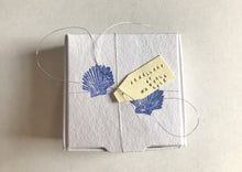 Load image into Gallery viewer, Handmade recyclable jewellery packaging. Sea shells. Pilgrim Symbol. Blue and white tied together with silver thread.